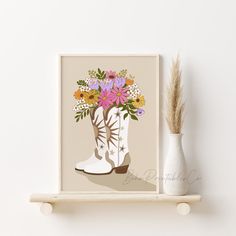 a white vase filled with flowers sitting on top of a shelf