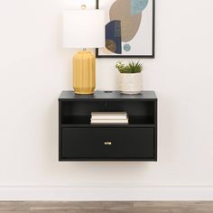 a black nightstand with a yellow vase next to it and a painting on the wall