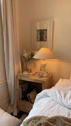 a bed room with a neatly made bed and a night stand next to the window