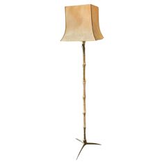 a floor lamp with a beige shade on it