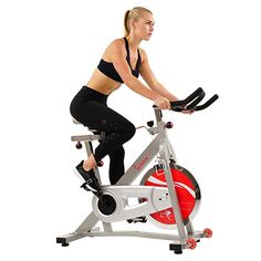 a woman is riding an exercise bike on a white background with red and black accents