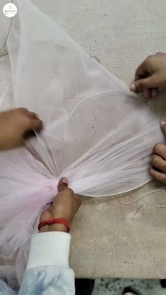 two people are working on something with plastic