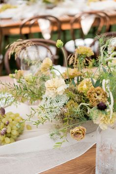 the table is set with flowers and greenery