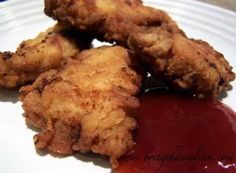 some fried food on a white plate with ketchup