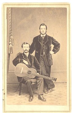 an old photo of two men with guitars