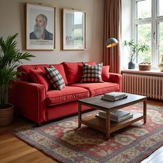 a living room with red couches and pictures on the wall above them, along with a coffee table