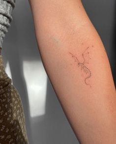 a woman's arm with a tattoo on it that has a lizard drawn on it