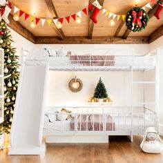 a white bunk bed sitting next to a christmas tree