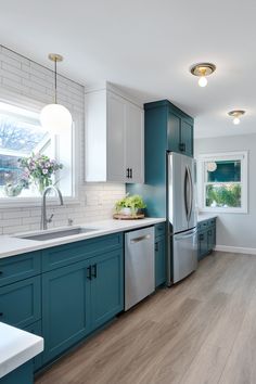 a kitchen with blue cabinets and white counter tops is pictured in this image from the front view