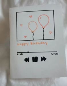 a happy birthday card with two balloons and an arrow in the middle, on top of a sheet of white paper