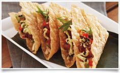 three tortillas on a white plate with green garnish and red peppers