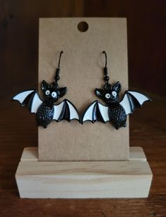 Handmade earrings with cute enamel Halloween charm.  Double backings automatically included. Nickel-free Black Spooky Earrings, Handmade Black Enamel Earrings, Cute Black Dangle Jewelry, Black Enamel Earrings, Pierced, White Drop Earrings For Halloween, Fun Black Jewelry For Halloween, Fun Black Halloween Jewelry, Gothic White Dangle Jewelry, White Gothic Dangle Jewelry