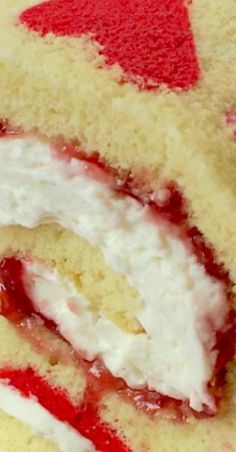 a close up of a cake with white frosting and red hearts on it's edges