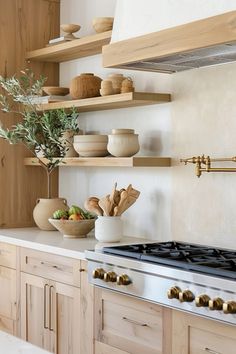 a stove top oven sitting inside of a kitchen next to wooden cupboards and shelves