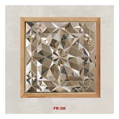 a mirror that is on the wall in front of a wooden frame with an abstract design