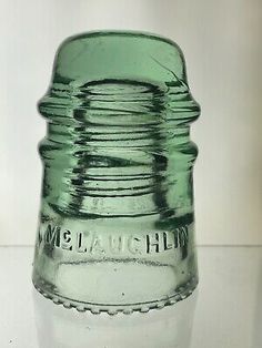 a green glass bottle sitting on top of a table