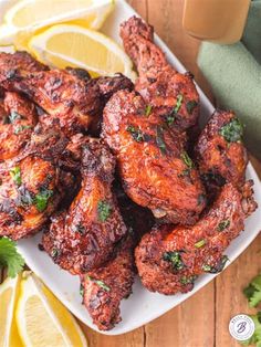 chicken wings on a plate with lemons and parsley