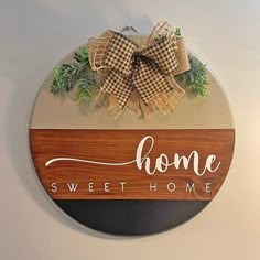 a wooden sign that says home sweet home with a bow hanging on the front of it