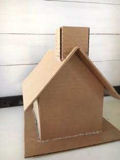 a cardboard house sitting on top of a table