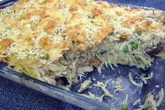 a casserole dish with meat and vegetables in it on a blue tablecloth