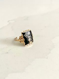 STUNNING bold and regal vintage yellow gold ring with a rectangular black onyx stone in the center and gorgeous scalloped ornate detailing beneath the gold pedestal holding the onyx up. The onyx bears a silver letter "B" on top with a small but mighty diamond stone in the corner. This is an incredible, highly sought-after art deco signet ring. This is estimated to be an antique piece. There is a symbol stamped inside the band beside which I cannot make out. This is presumably the maker's mark but possibly also the gold content. It appears to be a triangle, which apparently has roots in England and may even indicate a higher gold content, such as 14K. Size is approximately 6 - 6.25. Total weight is approximately 2.59 grams. *Note: This listing will ship with TRACKING to ALL destinations, in Heirloom Style Signet Ring With Black Enamel As Gift, Heirloom Signet Ring With Black Enamel For Anniversary, Black Vintage Engraved Ring With Polished Finish, Black Engraved Gemstone Ring For Anniversary, Black Rectangular Stone Ring For Anniversary, Vintage Black Engraved Ring For Gift, Classic Black Engraved Ring Stamped 14k, Engraved 14k Black Gold Jewelry, Antique Black Engraved Ring As Gift