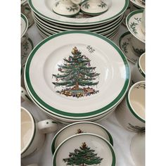 a table topped with lots of plates and bowls filled with christmas tree designs on them