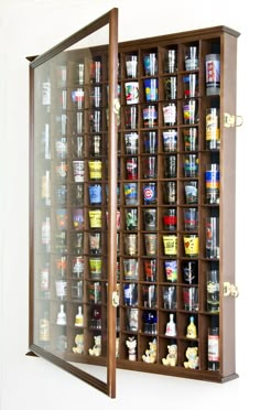 a display case filled with lots of different types of liquor in front of a white wall