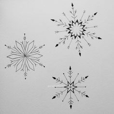 three snowflakes drawn in black ink on white paper, each with different shapes and sizes