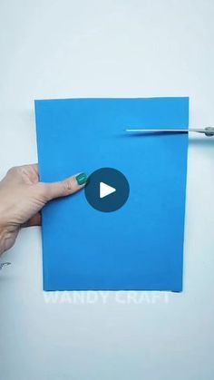 a person holding a piece of blue paper with a toothbrush on top of it