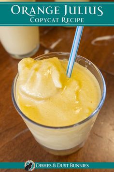 an orange juice in a glass with a straw