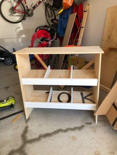 an unfinished shelf with the word love spelled out on it in front of some tools