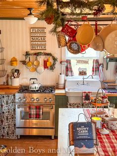 a kitchen decorated for christmas with pots and pans hanging from the ceiling, stove top oven