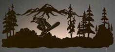 a silhouette of a snowboarder jumping over some rocks and trees in the background