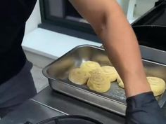 a person cooking food on top of a metal pan