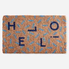 a door mat with the word hello spelled in blue letters on it and sprinkles