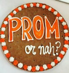 a decorated cookie with the words prom or man written on it in orange and white