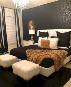 a bedroom with black and white walls, fur rugs on the floor and a large bed