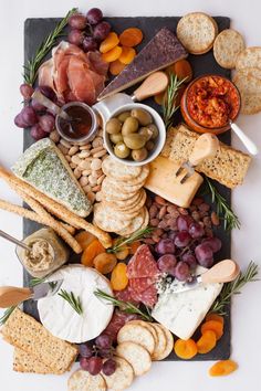 a platter filled with different types of cheeses and crackers on top of each other