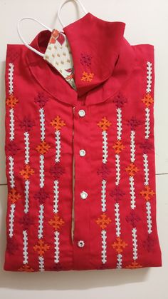 a red shirt with white and orange designs on it