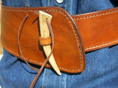 a leather belt with a wooden handle on the side and a piece of wood sticking out of it