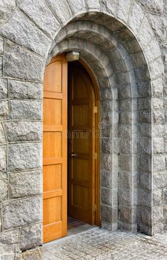 an arched wooden door in a stone wall stock photos, images and clippings