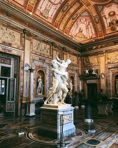 an ornate room with statues and paintings on the walls