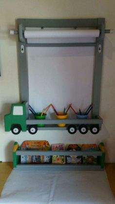 a child's play room with toys and books on the shelves, including a green toy truck