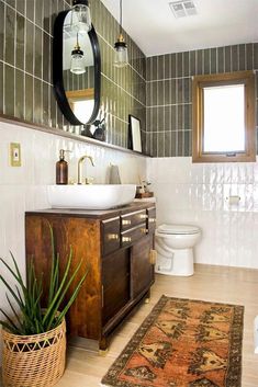 a bathroom with a sink, toilet and rug