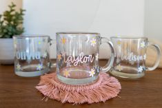 three glass mugs sitting on top of a wooden table