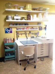 a desk with a chair in front of it and shelves on the wall behind it