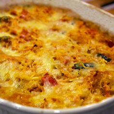 a casserole dish with cheese and vegetables in it sitting on a table top