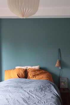 a bed sitting in a bedroom next to a blue wall