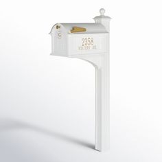 a white mailbox with gold lettering on it