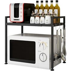 a white microwave oven sitting on top of a counter next to a shelf filled with bottles